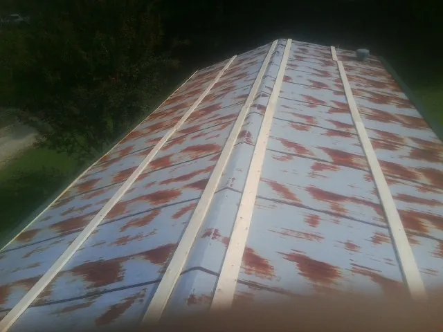 Rusted metal roof panels with new wood purlins before replacement — Storm Damage Roof Repair in Ashley by Roofing Brothers
