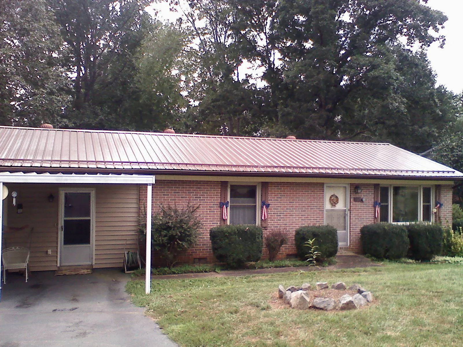 Bronze metal roof and carport on a brick ranch home — Roof Repair work by our crew in Ashley