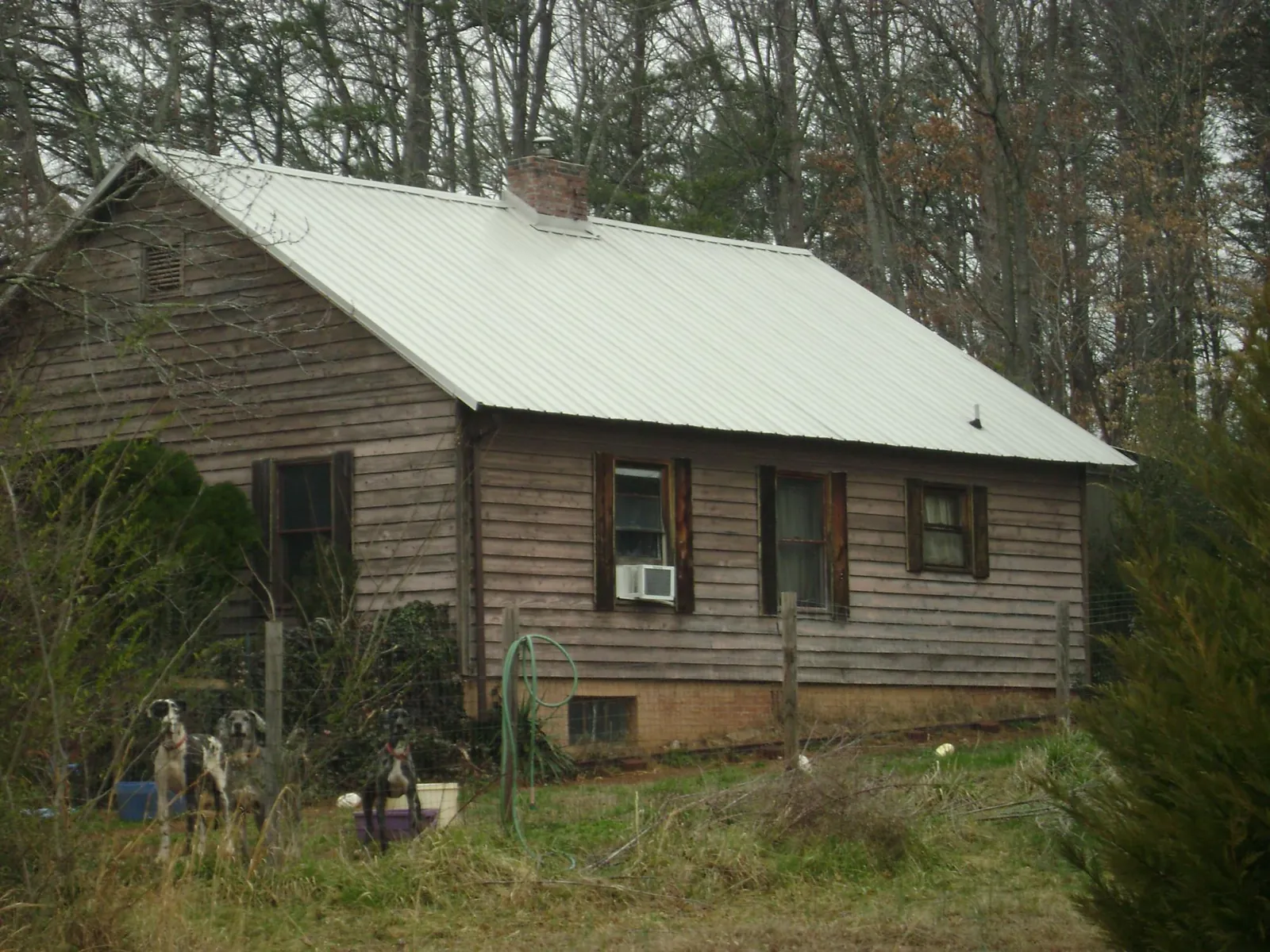 White metal roof on an old wood sided farmhouse, from a Metal Roof Installation job in Ashley